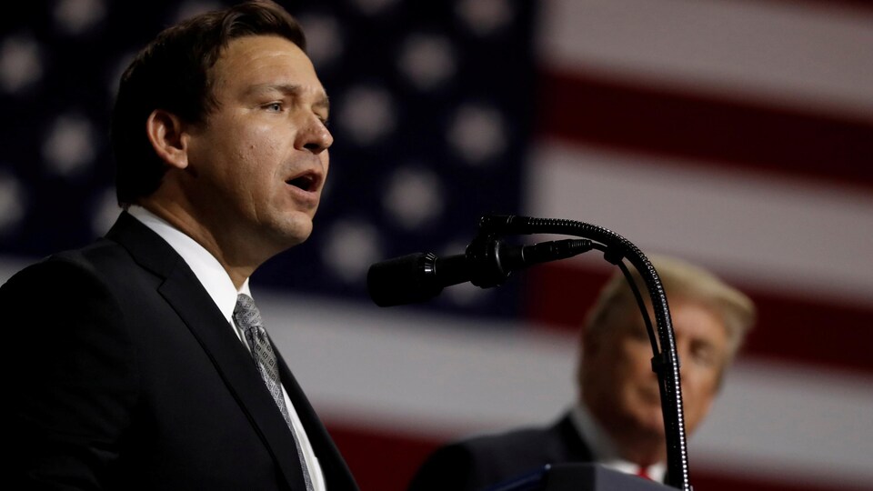 Ron DeSantis s'adressant aux militants républicains lors d'un rassemblement partisan du président Trump, qu'on aperçoit à ses côtés