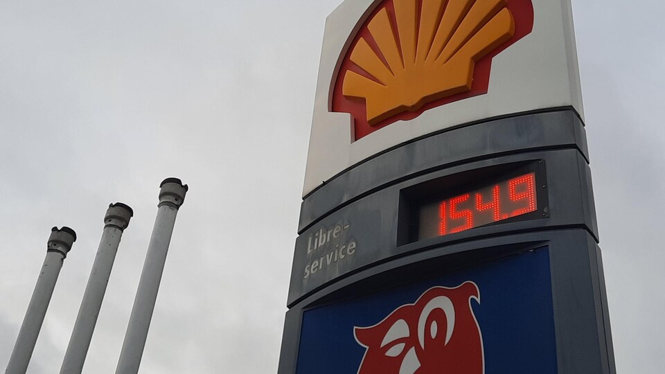 Une affiche de station-service affichant le prix de 154,9 cents par litre.