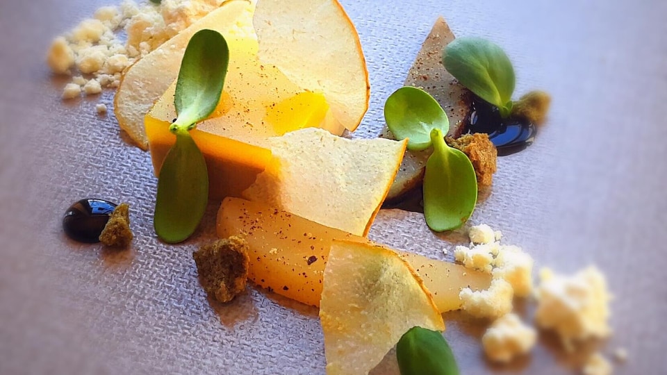 Gros plan sur un plat du restaurant Narval à Rimouski. Rubans de poires avec foie gras, poivre et pousses de tournesol.