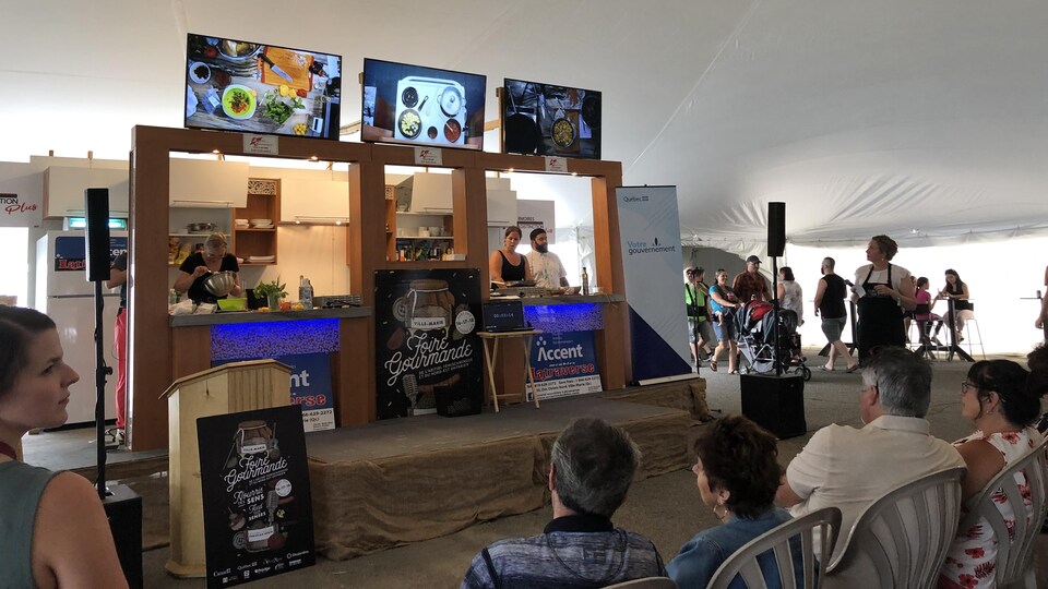 Des chefs cuisinent en direct devant une foule.