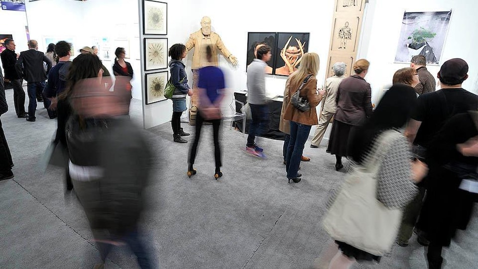 Des personnes circulent au sein d'une galerie d'art.