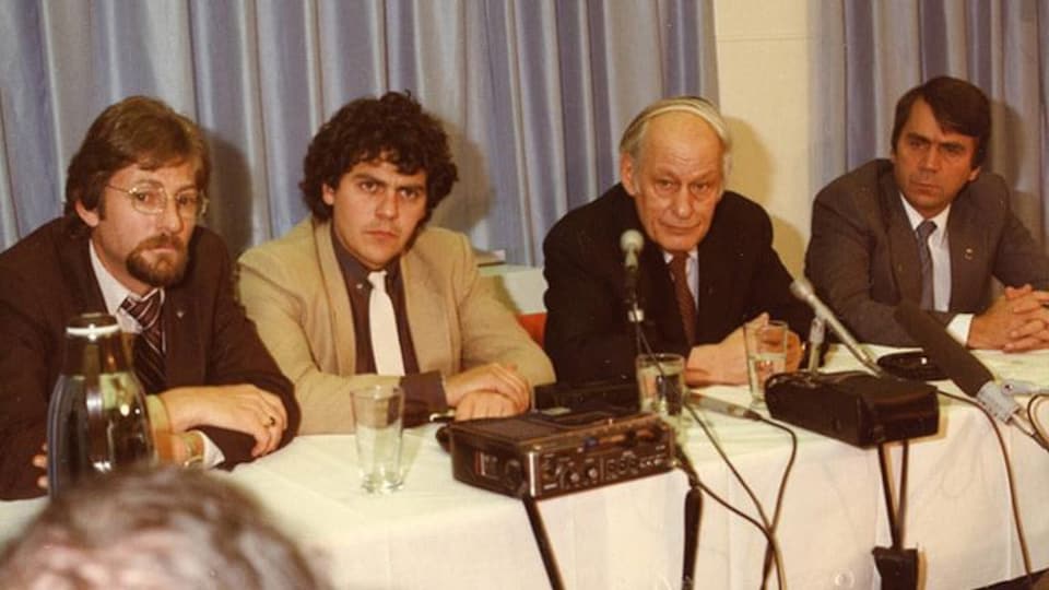 Une photo d'archives montre quatre hommes derrière une table, dont René Lévesque et François Gendron.
