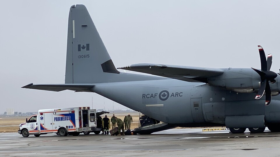 Transfert de matériel entre une ambulance et un avion militaire des forces armées canadiennes en Saskatchewan.