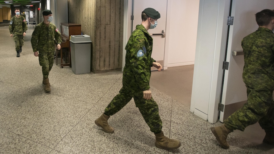 Des militaires portant un masque respectent une bonne distance entre eux.