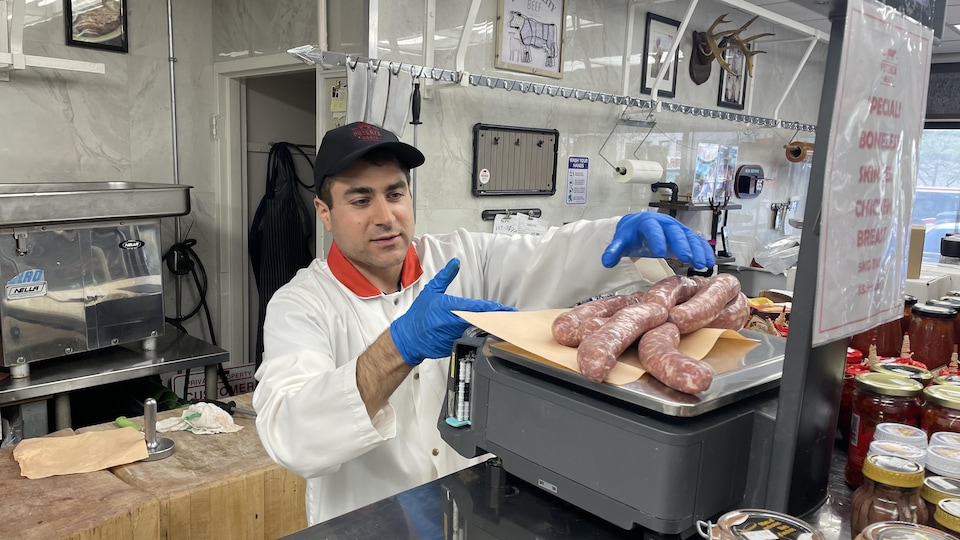 Le boucher Stephen Linardi pèse des saucisses de porc fraîches dans son commerce situé au coeur de la Ford Nation.