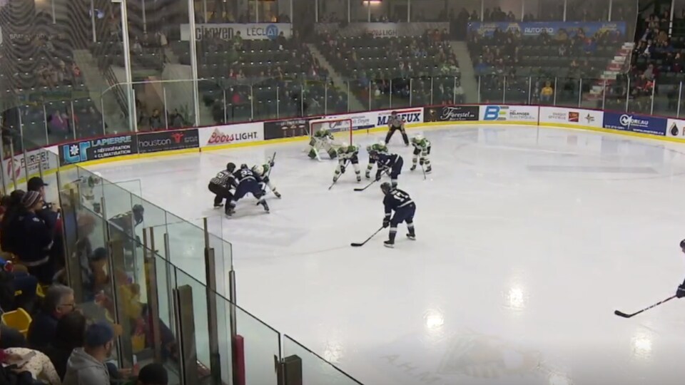 Des joueurs de hockey se disputent une partie dans un aréna