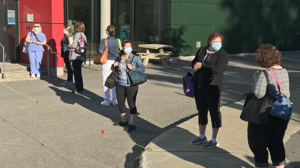 Les premières personnes dans la file pour entrer dans les locaux de formation, lundi matin.