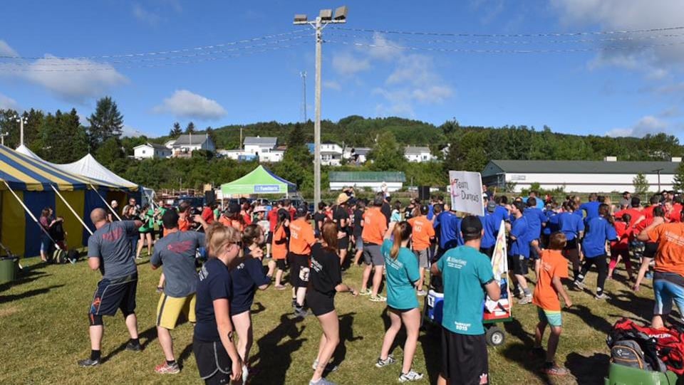 Des participants s'échauffent en plein air avant de débuter les épreuves.