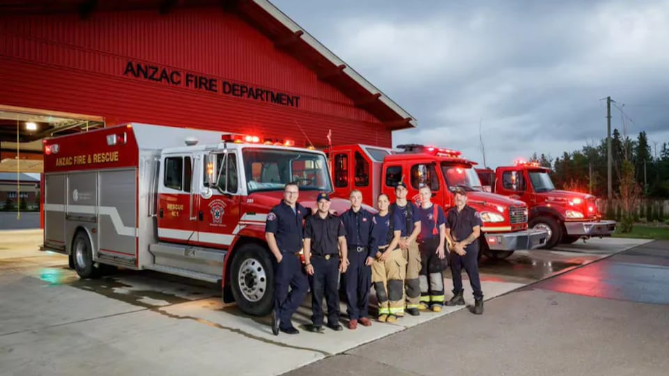 Les pompiers d'Anzac posent devant leurs camions garés devant la caserne.