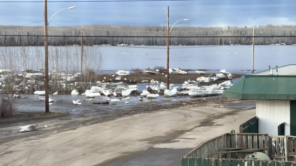 Des blocs de glace sur une route à côté d'un fleuve à Fort Simpson.