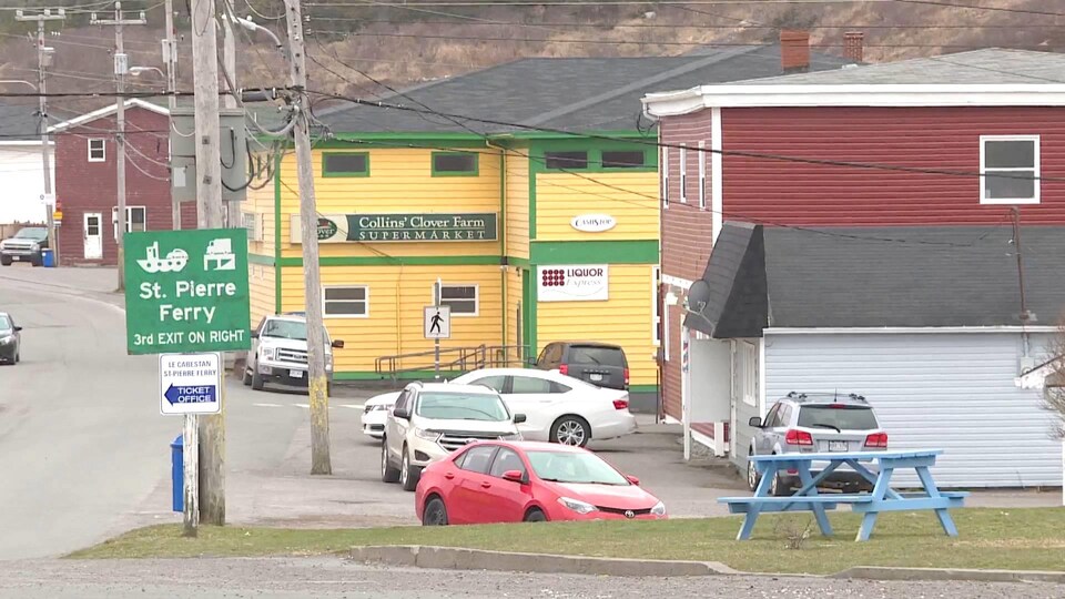 Un bâtiment jaune abritant une épicerie et un magasin d'alcool.