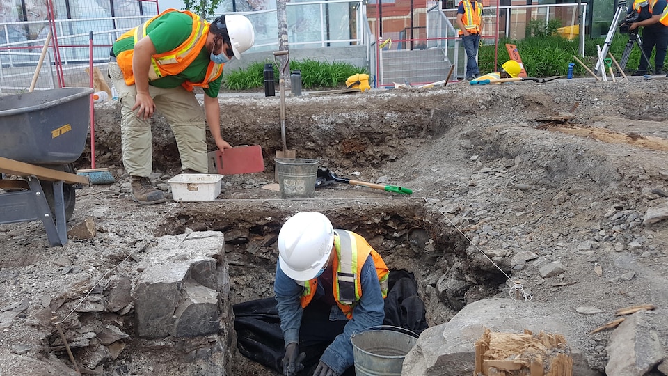 Deux hommes mènent des fouilles sur un site archéologique.