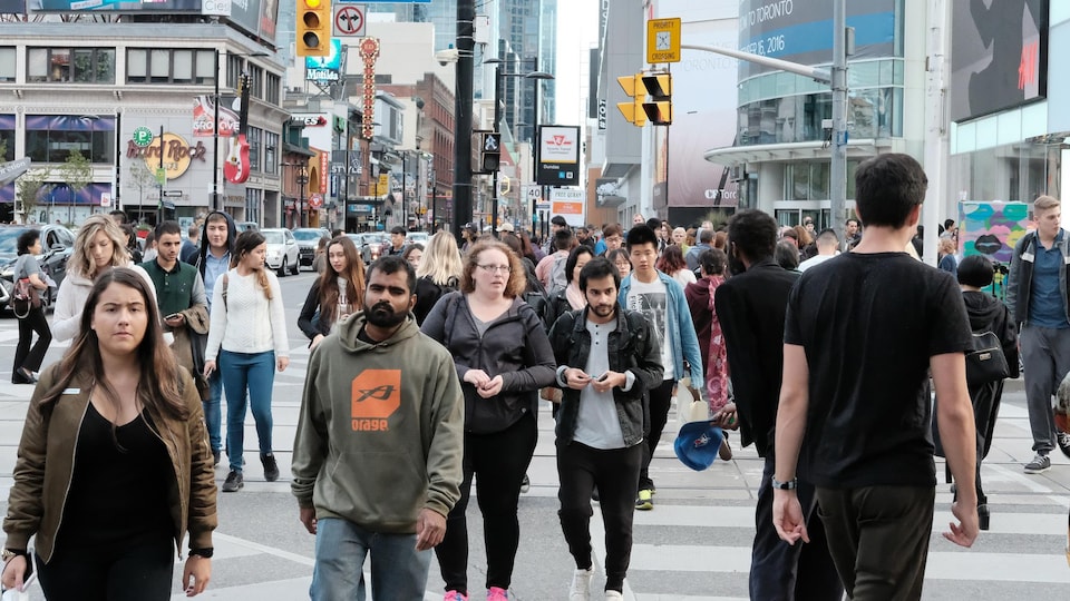 Des passants marchent dans la rue à Toronto.