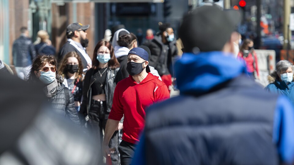 Des gens marchent dans la rue au soleil.