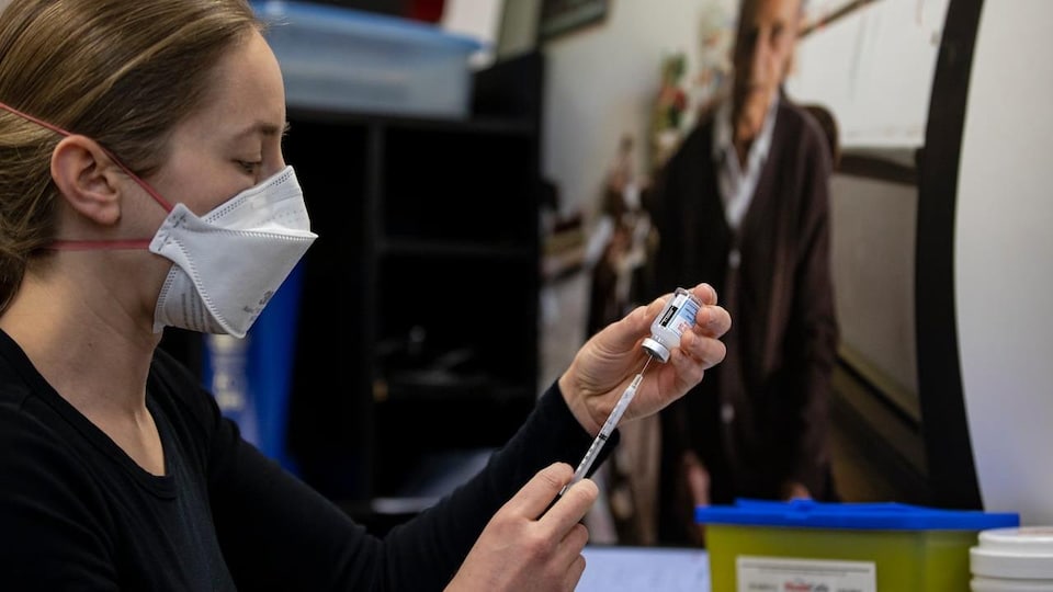 Une infirmière prépare une dose du vaccin contre la COVID-19.