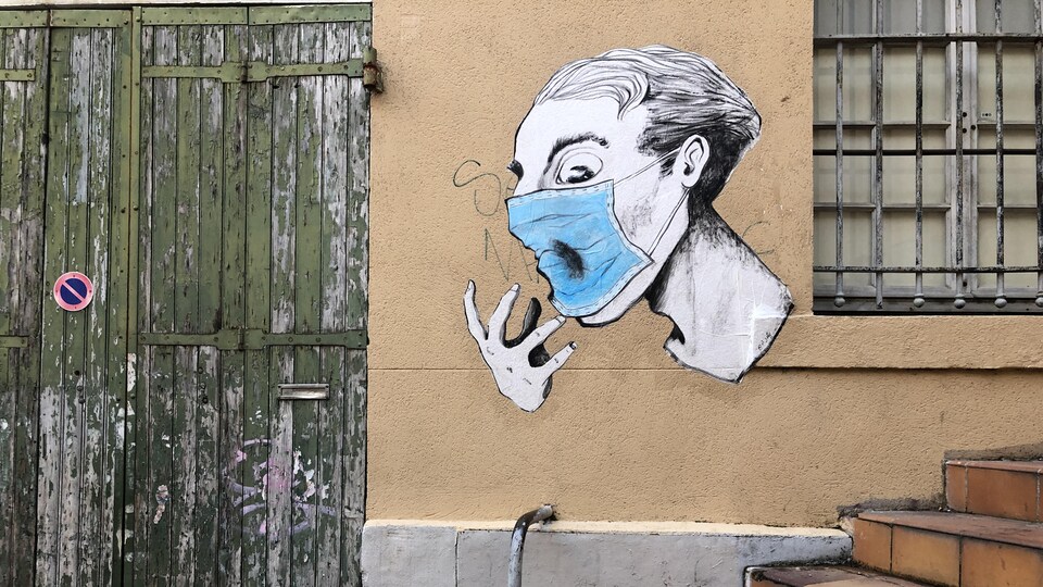 Un graffiti montre une personne qui porte un masque.