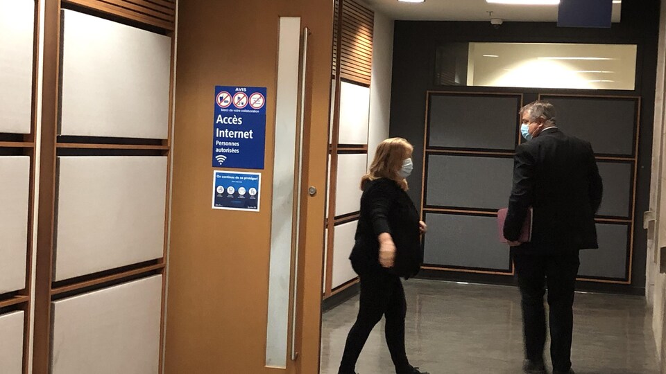 Une femme et un homme dans le couloir du palais de justice.