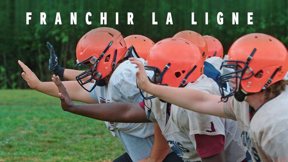 Des jeunes joueurs de football mettre une main vers l'avant.