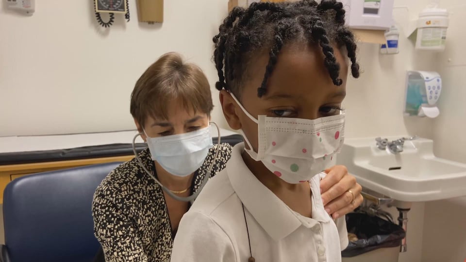 La médecin écoute l'enfant respirer.