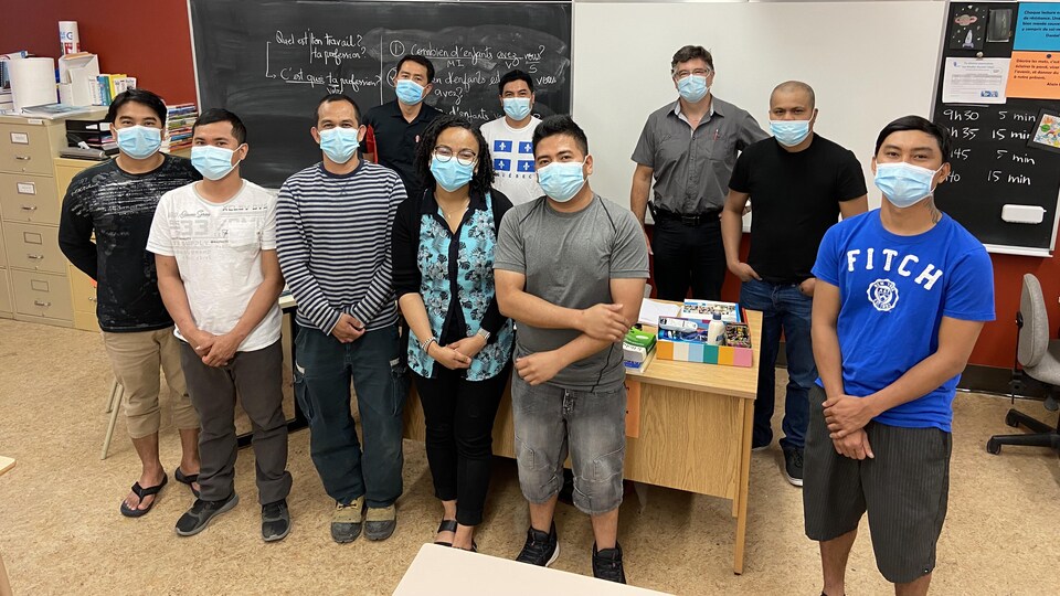 Un groupe dans une salle de classe devant un tableau.