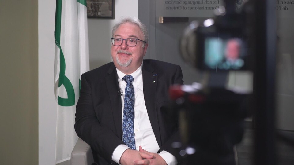 François Boileau est assis dans un fauteuil et répond aux questions de Radio-Canada. 