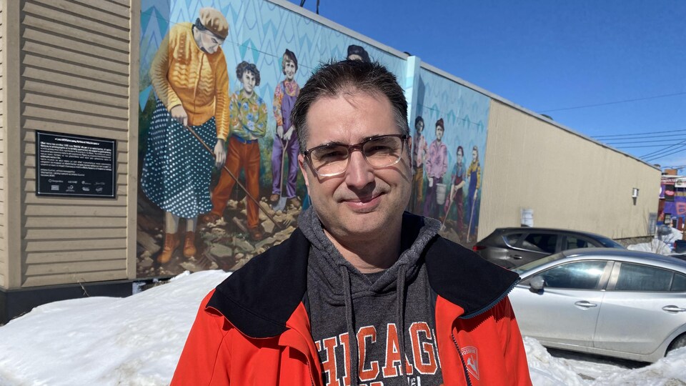 François Deschênes près d'une murale représentant des femmes, à Rouyn-Noranda.