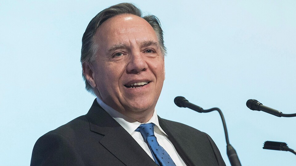 Le premier ministre Francois Legault devant des micros.