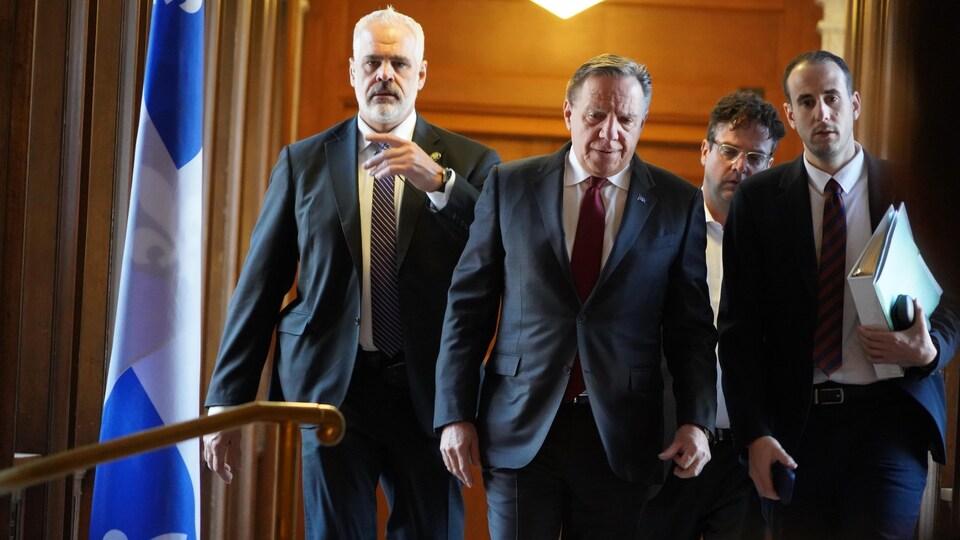 François Legault marchant dans un corridor du parlement.