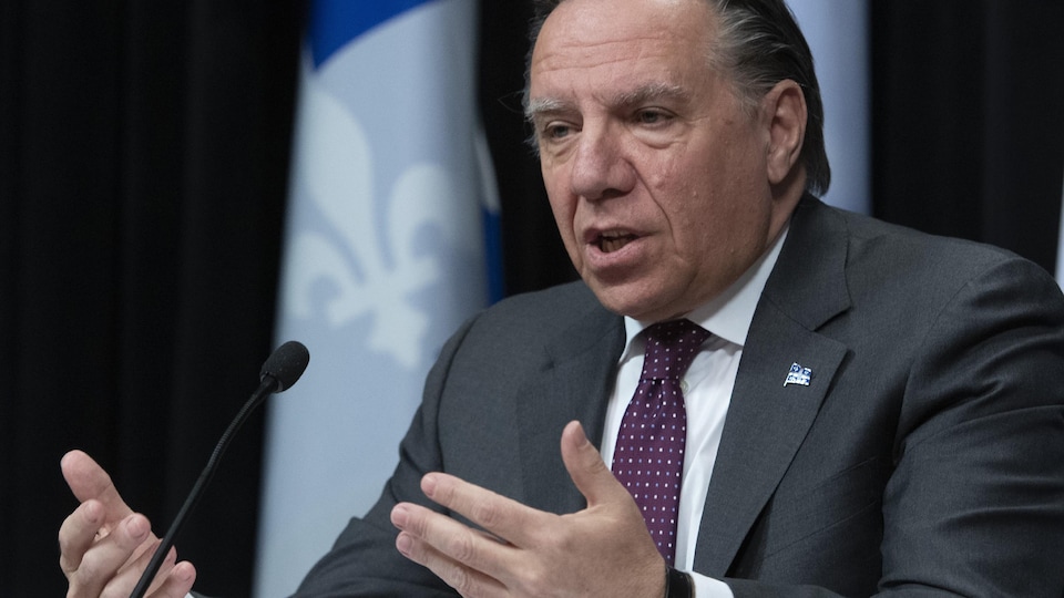 François Legault parle devant un micro.