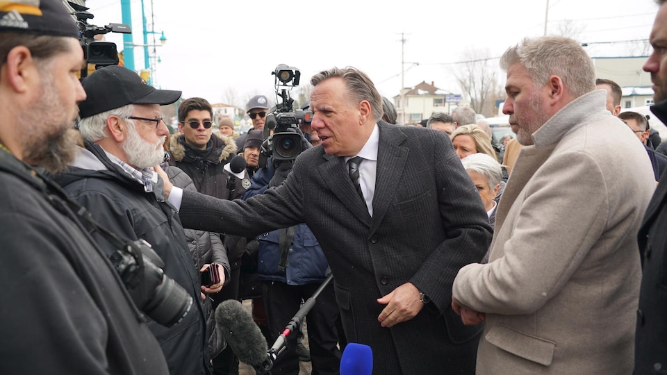 Le premier ministre met sa main sur l'épaule d'un homme.