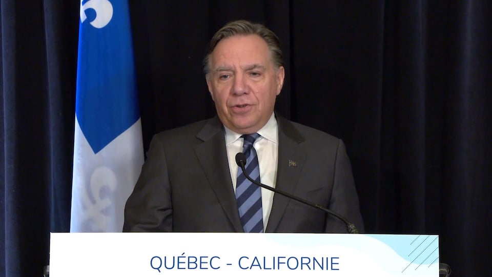 François Legault debout derrière un lutrin.