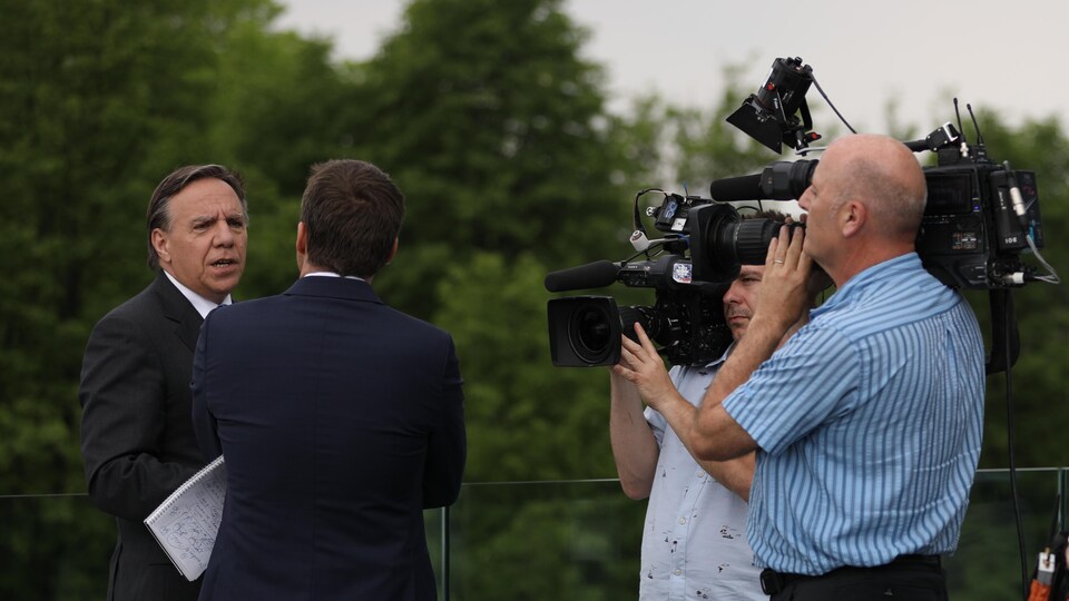 François Legault en entrevue, entourés de 2 caméramans.