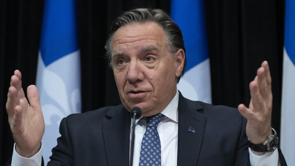 Les mains levées, François Legault répond à une question d'un journaliste lors d'un point de presse.