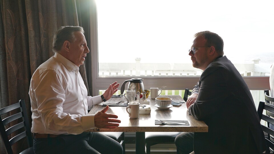 Tous deux assis à une table de restaurant, François Legault discute avec Jonathan Lapierre.
