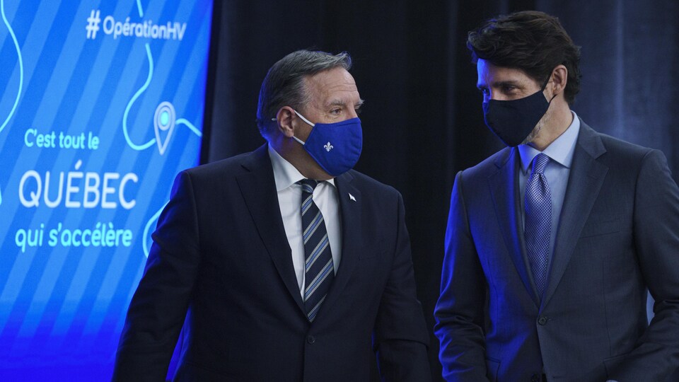 Les deux politiciens discutent avec leurs masques. 