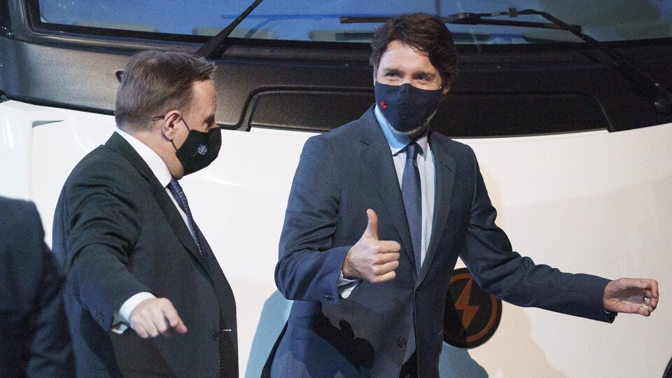 François Legault et Justin Trudeau portant un masque sont debout l'un à côté de l'autre.