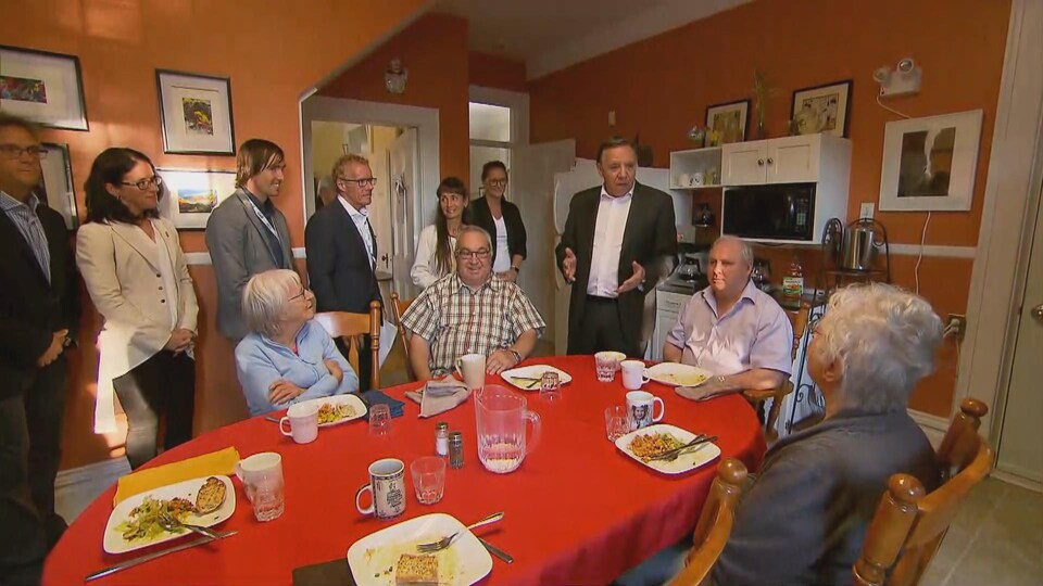 François Legault dans la cuisine avec des résidents et les candidats locaux de la CAQ