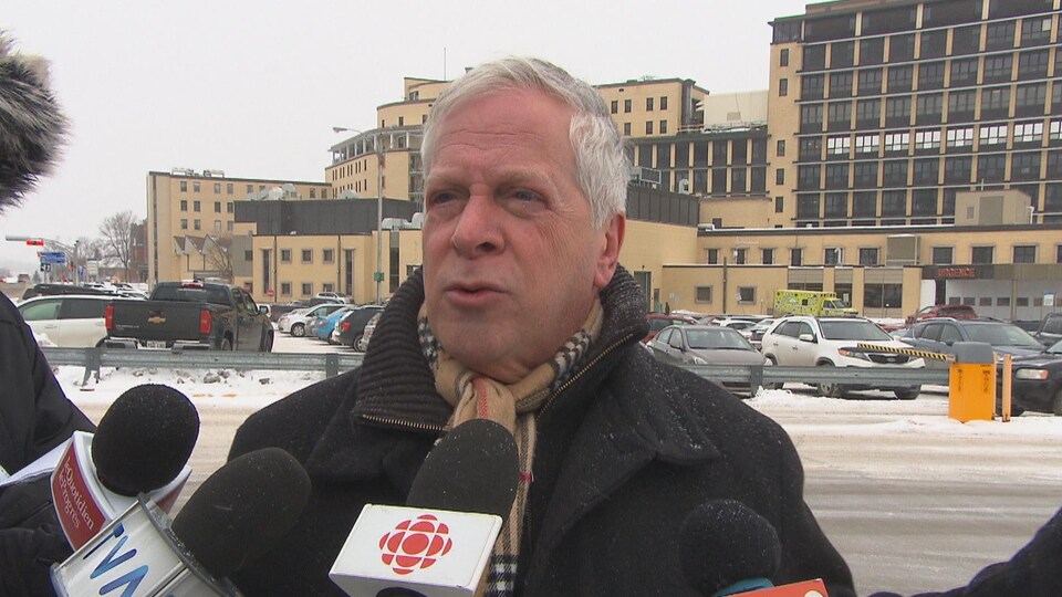 François Paradis devant les micros des journalistes près de l'aéroport.