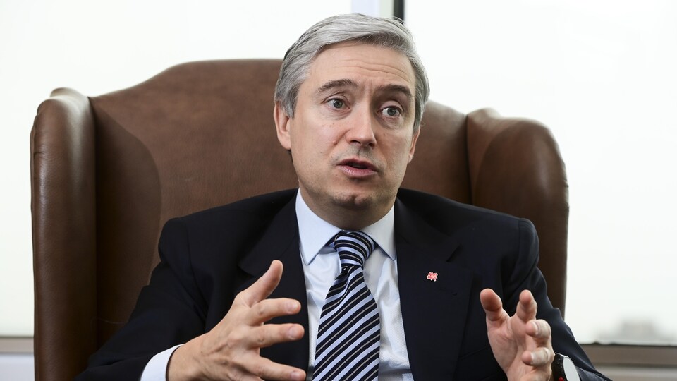 Assis dans un grand fauteuil, François-Philippe Champagne parle.