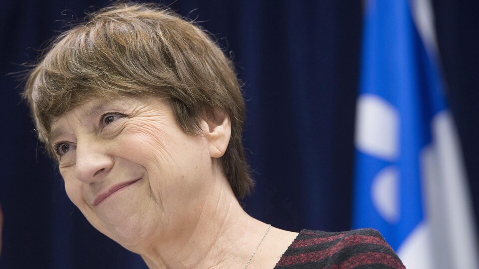 Françoise David est photographiée en gros plan devant un drapeau du Québec.
