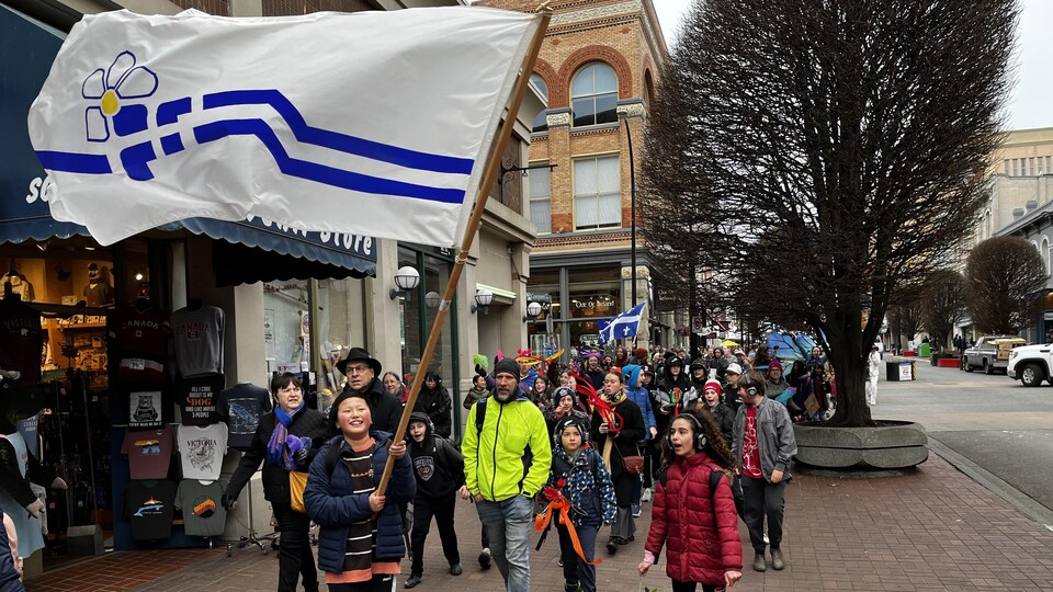 Un drapeau franco-colombien tenu dans les airs par un enfant lors d'un défilé à Victoria pour célébrer la présence francophone en Colombie-Britannique, le 9 mars 2023.