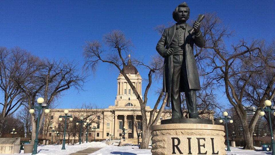 La statue de Louis Riel en avant-plan, la façade de l'assemblée législative du Manitoba en arrière-plan.
