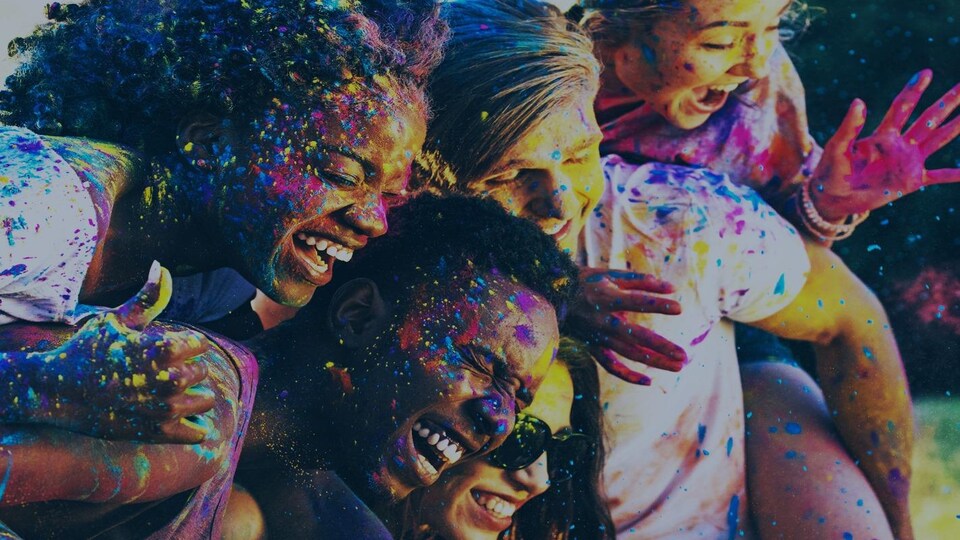 Des jeunes issus de l'immigration sourient en étant éclaboussés de peinture.