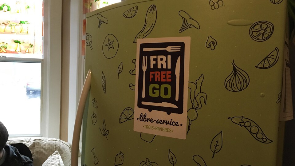 Un réfrigérateur peinturé en vert, avec des dessins