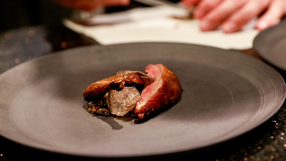 Assiette avec une cuisse de volaille, des lamelles de truffes.