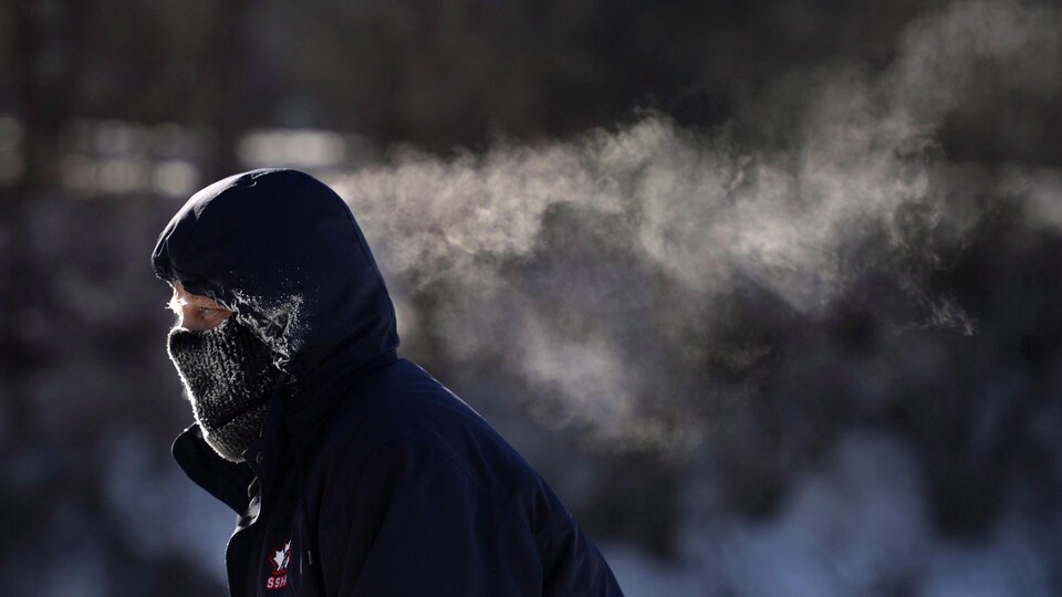La respiration d'un patineur fait des traînées de condensation derrière lui.
