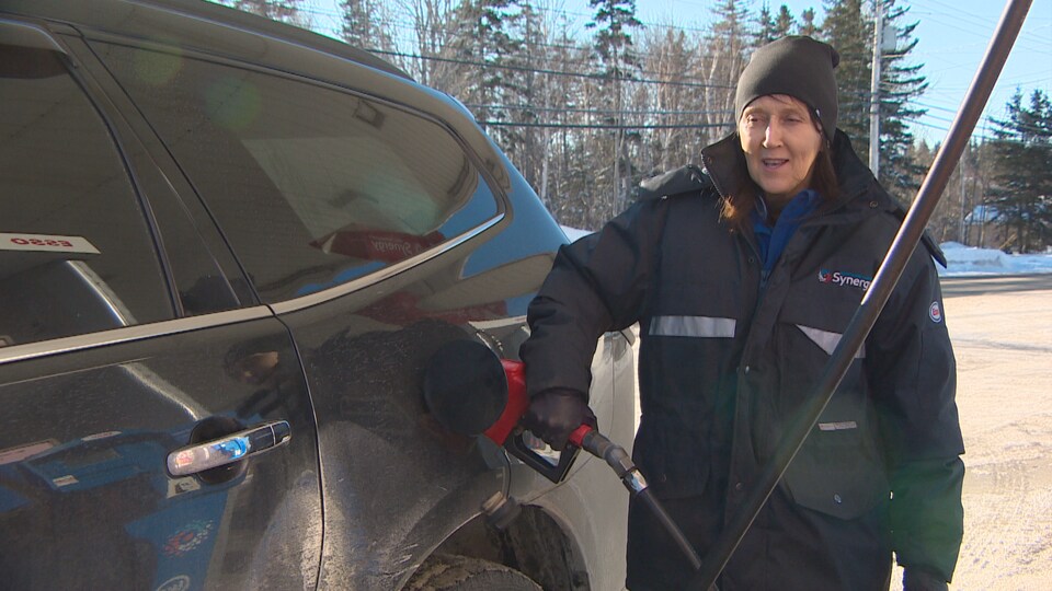 Sylvie Haché fait le plein d'essence d'une voiture à une station-service à Caraquet.