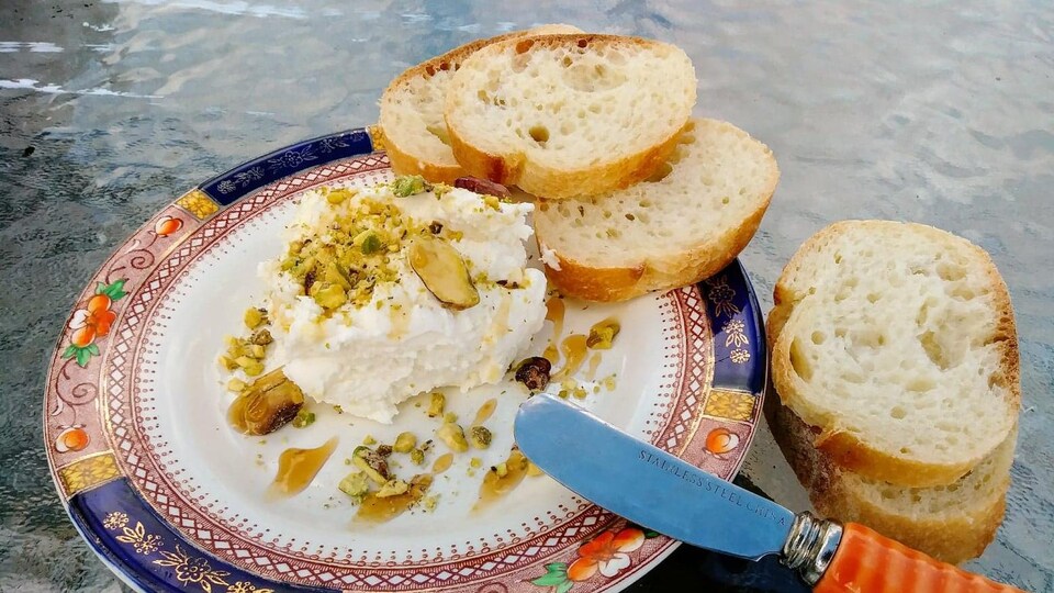 Du fromage dans un bol, accompagnée de pain.