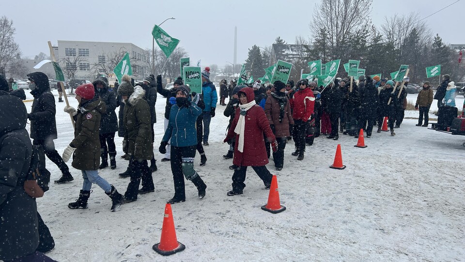 Des dizaines de personnes manifestent sous les flocons de neige qui tombent à Rouyn-Noranda.