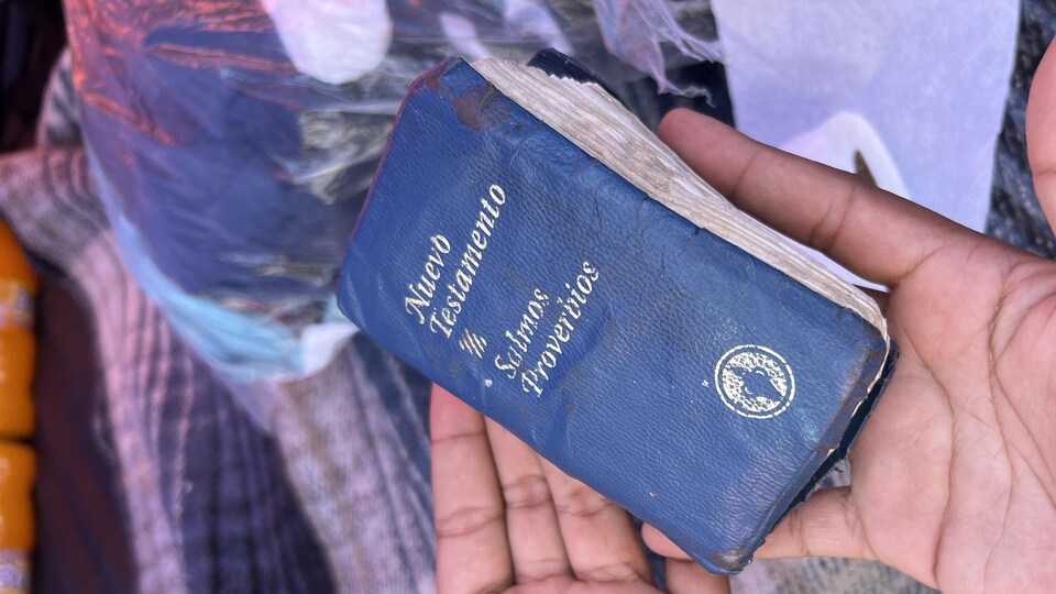 A New Testament in the hands of a migrant.